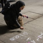 Salma sprüht Slogans auf den Steindamm. Foto: